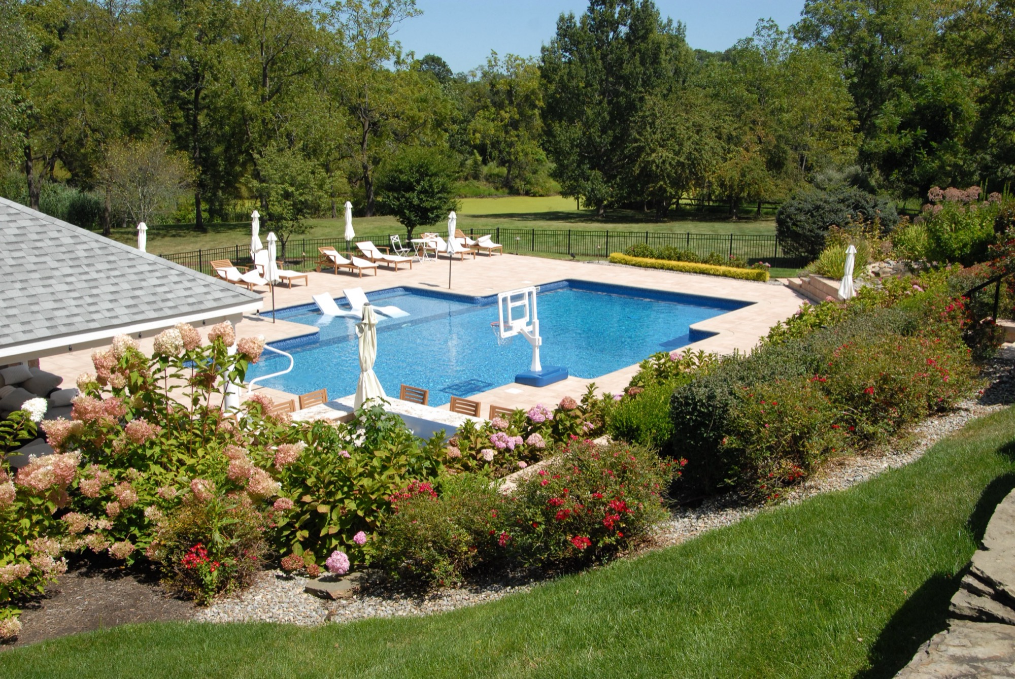 Custom inground pool at dusk with outdoor living and pool house in Holmdel, NJ