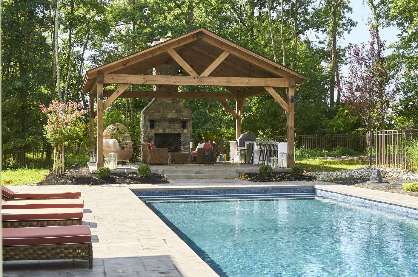 Backyard at dusk with pergola, pavilion, pool, and string lights