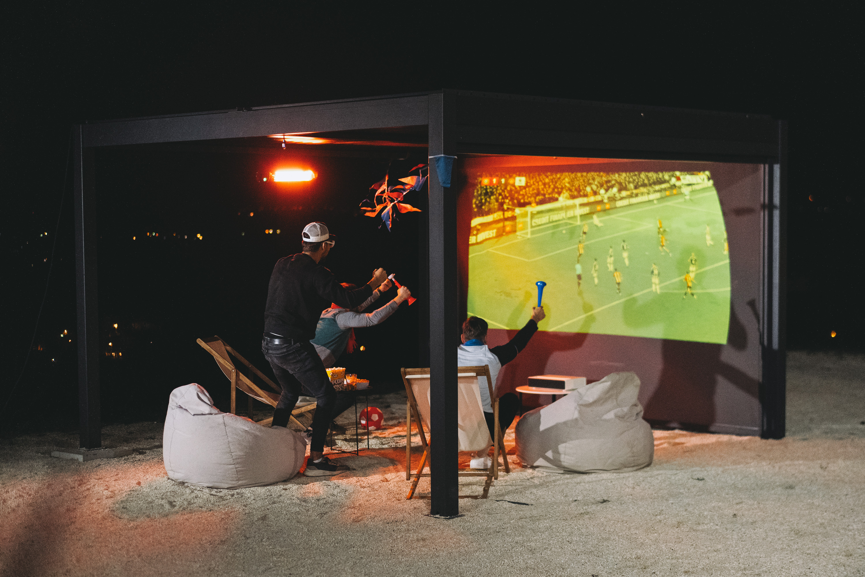 Hansø PRO+ 10×13 pergola covering a dining table and sofa