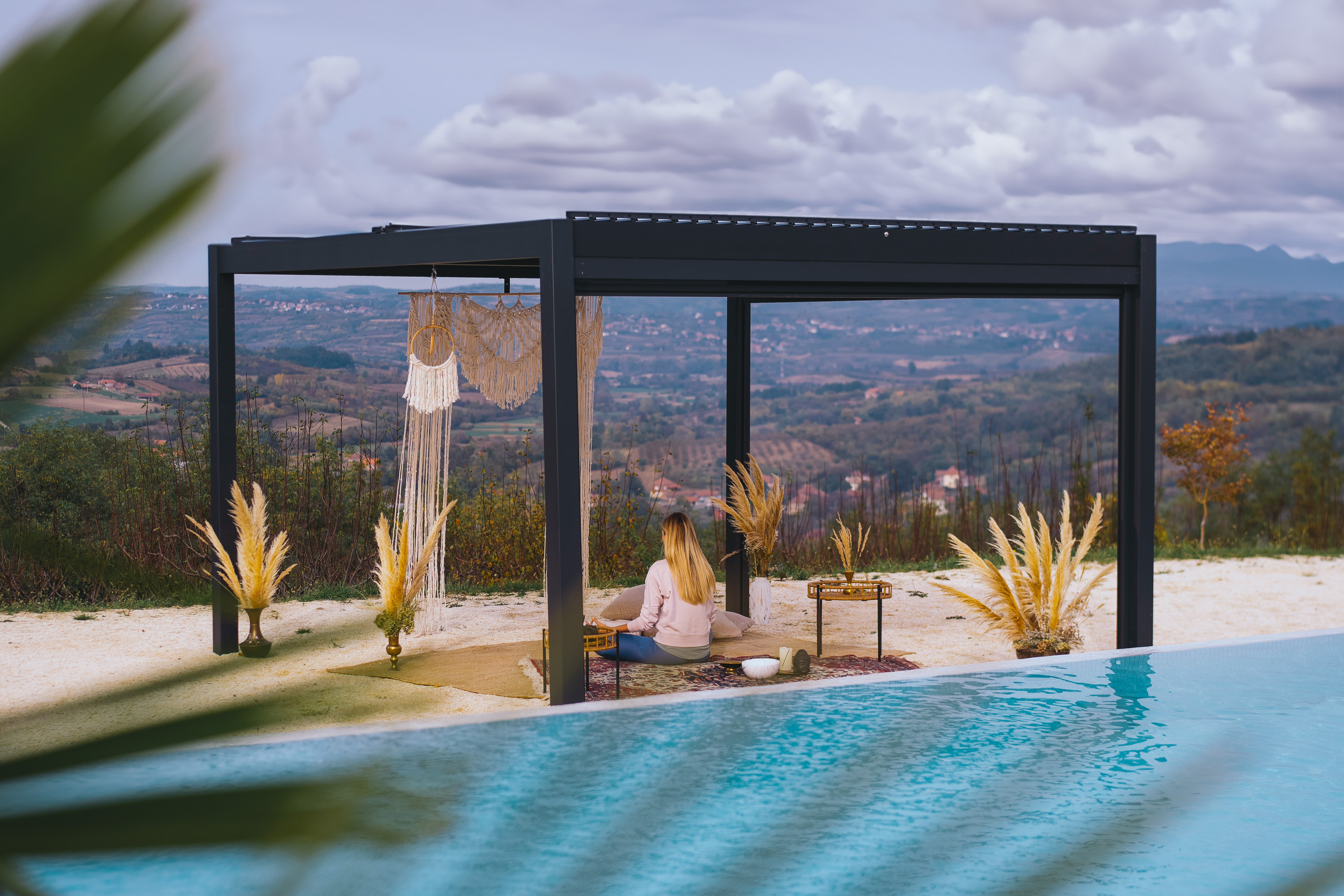 Hansø PRO+ 13×13 pergola over an outdoor kitchen and dining setup