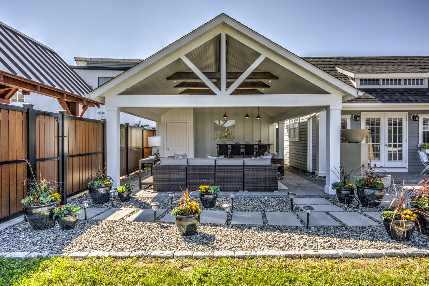 Homestead Avalon A-Frame pool house with platinum gray vinyl siding, exposed cathedral truss interior, and stone fireplace
