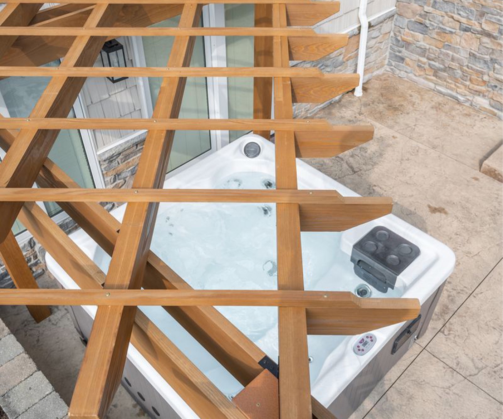 Berlin Gardens Alcove pergola covering a hot tub against a house
