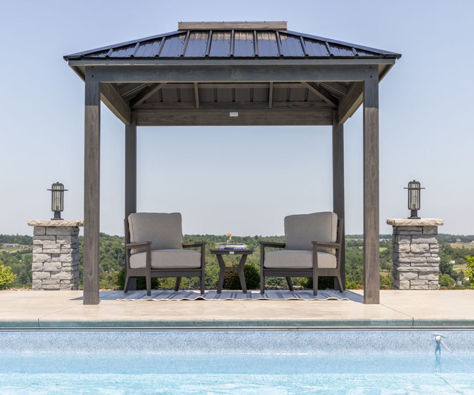 Berlin Gardens Windsor wood pavilion with Plexi-Glass Moon Roof and stained wood frame, set on a poolside patio